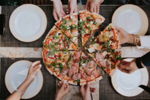 Een gedeelde pizza aan tafel